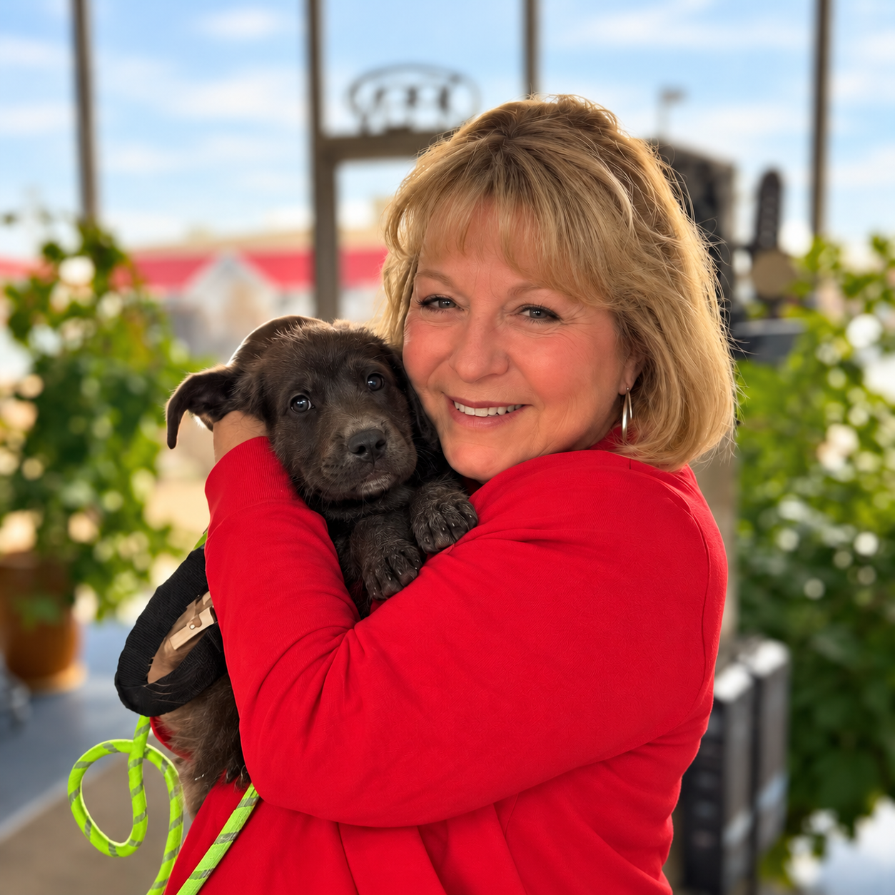 Teresa Angela McCann smiling while holding a small dark puppy